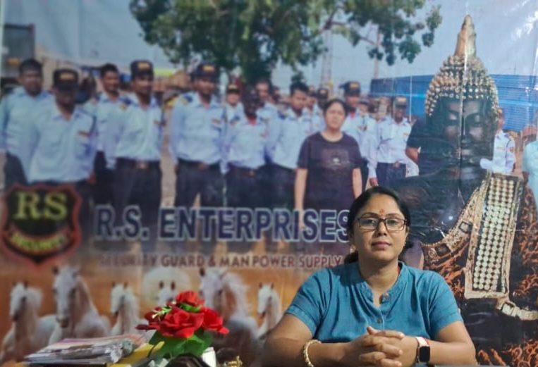 RS Enterprises office desk in front of the company banner